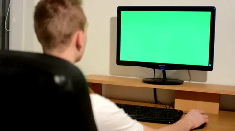 Young man writes on the keyboard and looks at the monitor - green screen Stock-Footage 36988112