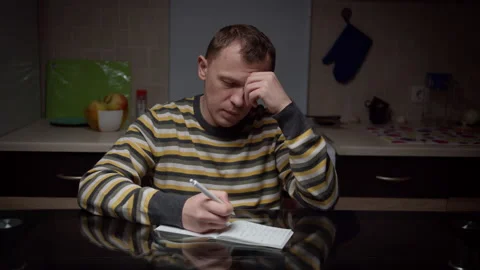 A young man writes in a notebook his plans for the future, planning things Stock Footage 134931643