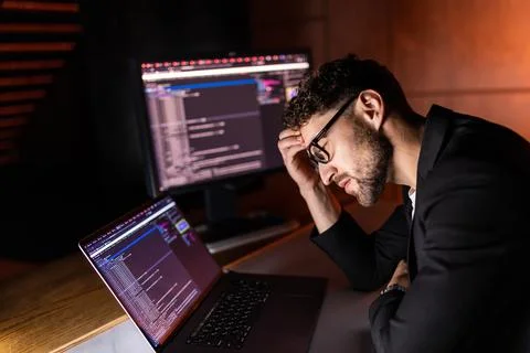 Young man writes program code on a computer, programmer work in home office. Stock-Fotos
