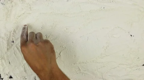 Young man writes a word bread on white flour Stock Footage 68762576