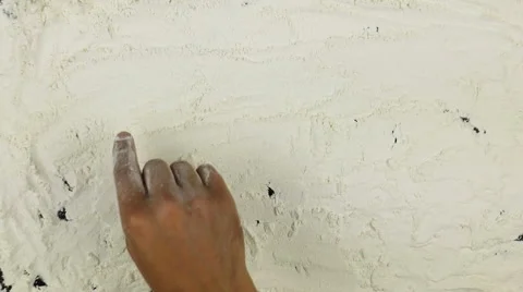 Young man writes a word cook on white flour Stock Footage 68762441