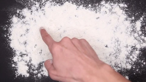 A young man writes the word I love you on white flour. Black table top view Stock Footage 120454735
