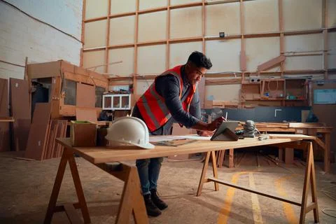 Young man writing with digitized pen on digital tablet on a-frame table in Stock Photos