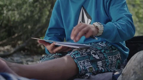 Young man writing in a notebook 库存影片 76737154