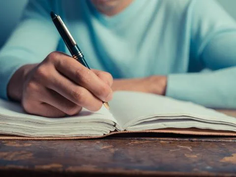 Young man writing in notebook 스톡 사진