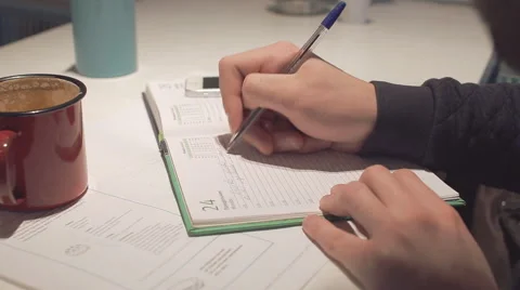 Young man writing in notepad in cafe, close-up Stock Footage 58641302