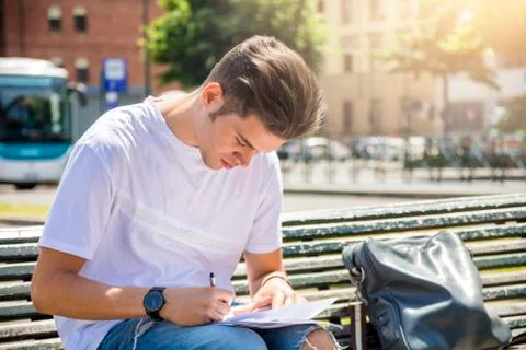 Young man writing notes on notepad in city Stock Photos