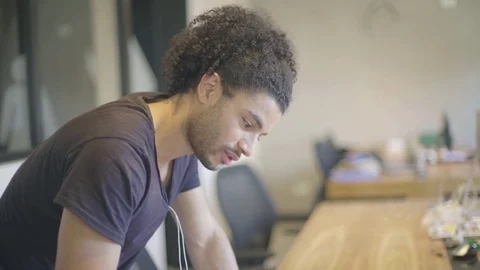 Young man writing notes in office Stock Footage 75794960