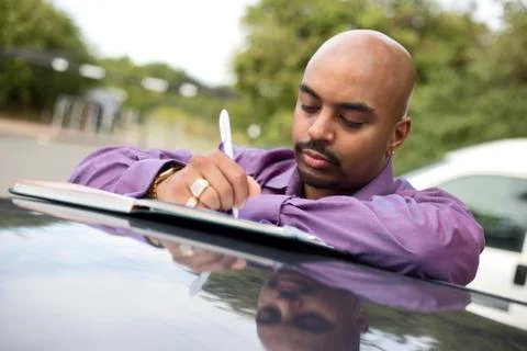 Young man writing notes in a textbook Stock Photos