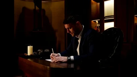 Young man writing on a paper Video stock 79342100