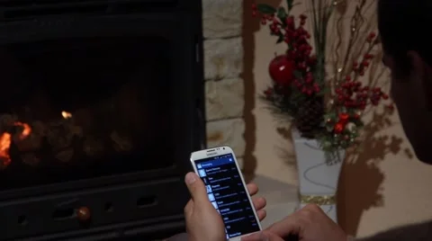 Young Man Is Writing An SMS In Front Of A Fireplace Communication Concept Stock Footage 44015499