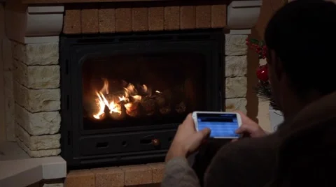Young Man Is Writing An SMS In Front Of A Fireplace Communication Concept Stock Footage 44015550