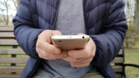 Young man writing a text message or downloading a mobile phone app Stock Footage 188340188
