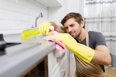 Young Man in Yellow Gloves Using Cleanser Stock-Fotos