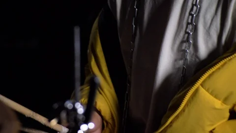 Young man in yellow jacket playing drums in the dark. 4K Stock Footage 96353735