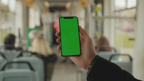 Young man young hand uses holding a mobile telephone with a vertical green Stock Footage 117941440
