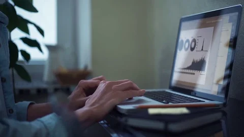 Young man young man using laptop making notes in notepad at home Stock Footage 82931332