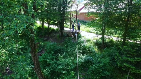 Young man on a zip line over the mountain river Stock Footage 114179820