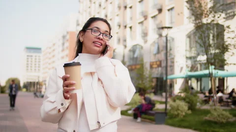 Young manager walking and talking on phone while drinking coffee Stock Footage 293228251