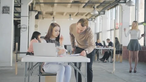 A young manager walks around the office, communicates with colleagues, and gives Stock Footage 108872073