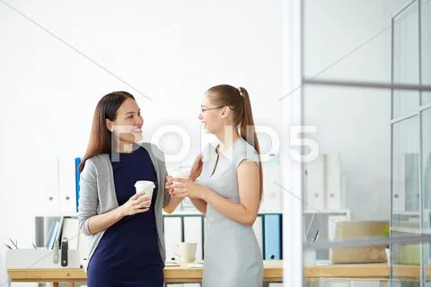 Young managers talking at coffee break in office Stock Photos