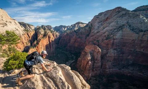 Young mans epic summit to top of Angels Landing trail - Zion National Park Stock Photos