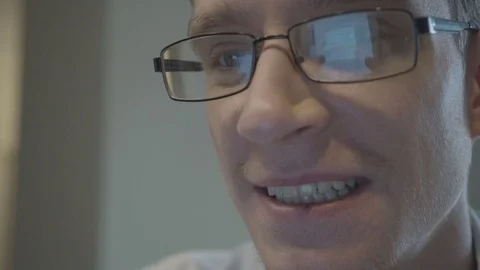 Young man's face in glasses reading text on the tablet screen Stock Footage 71061868