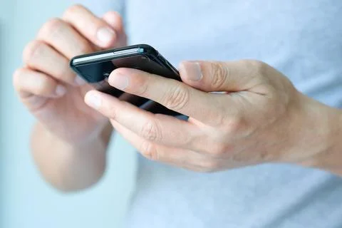 The young man's hand He is using a smartphone to connect with friends in th.. Stock Photos