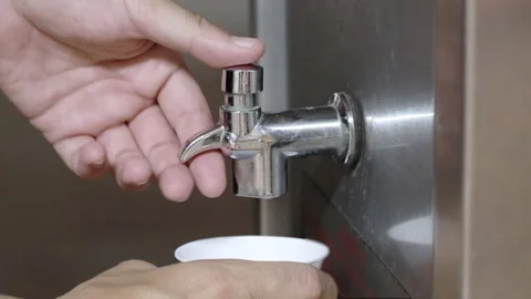 Young man's hand pressed the water dispenser that served in the office or uni Stock Footage 143894734