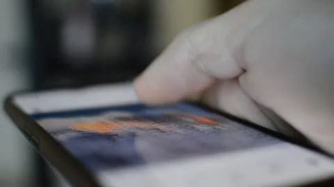 Young man's hand scroll social network app on phone display in blur background. Video stock 254782967