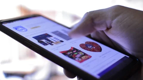 Young man's hand scrolling amazon shopping app looking for items. Stock-Footage 209479827
