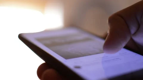 Young man's hand scrolling facebook social network app on his iphone. Video stock 209182762