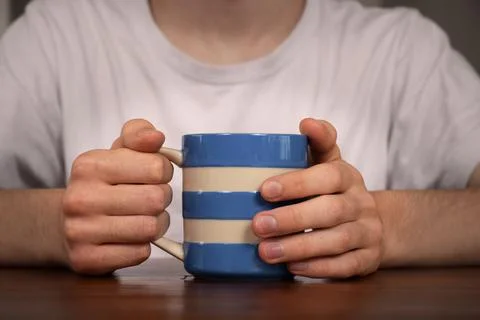 A young man's hands hold a hot drink Stock Photos