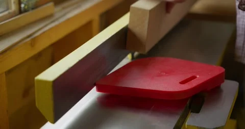 A young man's hands processing the edge of an oak plank on a planer Stock Footage 251796314
