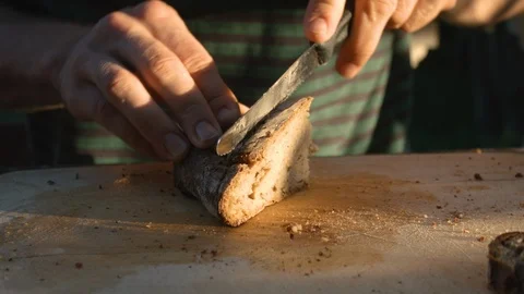 Young Man's Hands Slicing Delicious Bread In The Summer Sunset Sun In 4K Stock Footage 111728438
