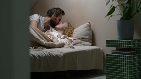 Young married couple sharing a tender morning moment in bed. 库存影片 329939849