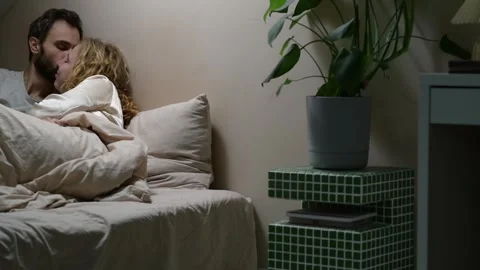 Young married couple sharing a tender morning moment in bed. 库存影片 329939850