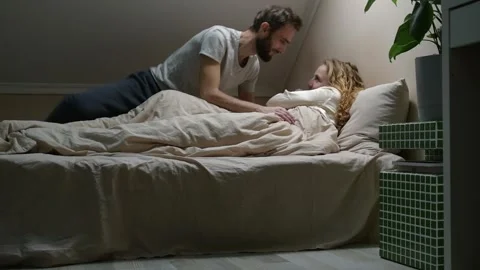 Young married couple sharing a tender morning moment in bed 库存影片 329939857
