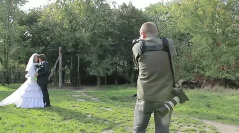 Young marrying couple . Photographing process in park Видео 20467198