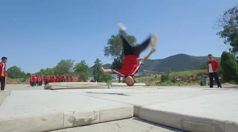Young martial arts students make back flips, martial arts institute China Vidéo 67547563