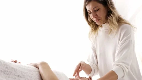 The young masseuse applying the massage technique to a client in the spa salon Stock Footage 228620832