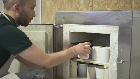 Young master is putting clay products in oven pottery workshop. Video stock 90131966