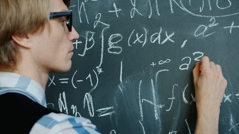 Young mathematician writing formulas on chalkboard working with serious face Stock Footage 124885347