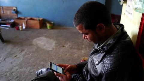 Young mechanic finding out the tool problems in his mobile on automobile app. Stock Footage 148087097