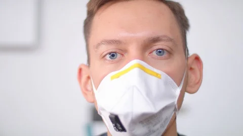 Young medic in blue gloves puts on a respirator. Stock Footage 130012470