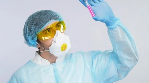 Young medical chemist analyzing test tube with pink liquid in protection suit Stock Footage 127035307