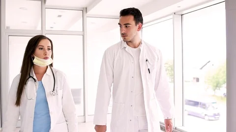 Young Medical Colleagues Talking While Walking Through Hospital Video stock 87768774