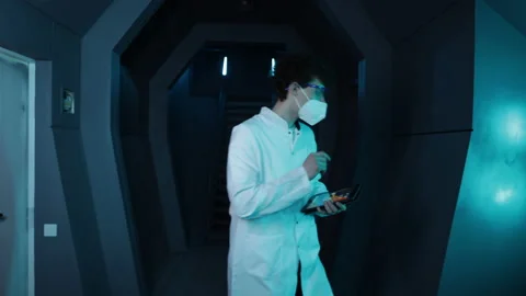 Young medical worker making notes while walking along corridor Stock Footage 239556777