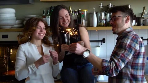 Young men and two young women burn the Bengal lights in the kitchen with Stock Footage 75233416