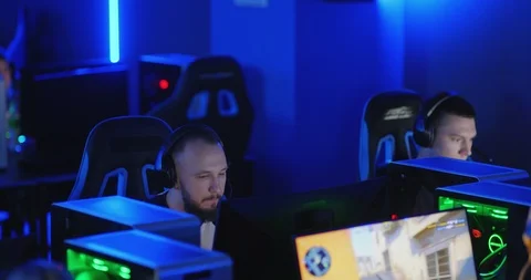 Young men are sitting in a computer club, playing an online game. Сoncentrated Stock Footage 126018586